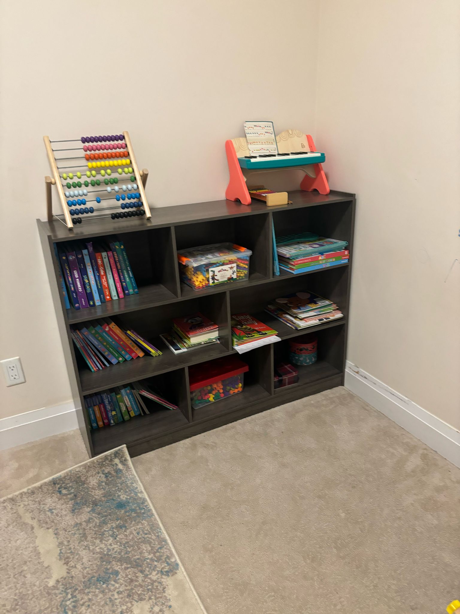 Bookshelf with abacus, toy piano, and learning materials
