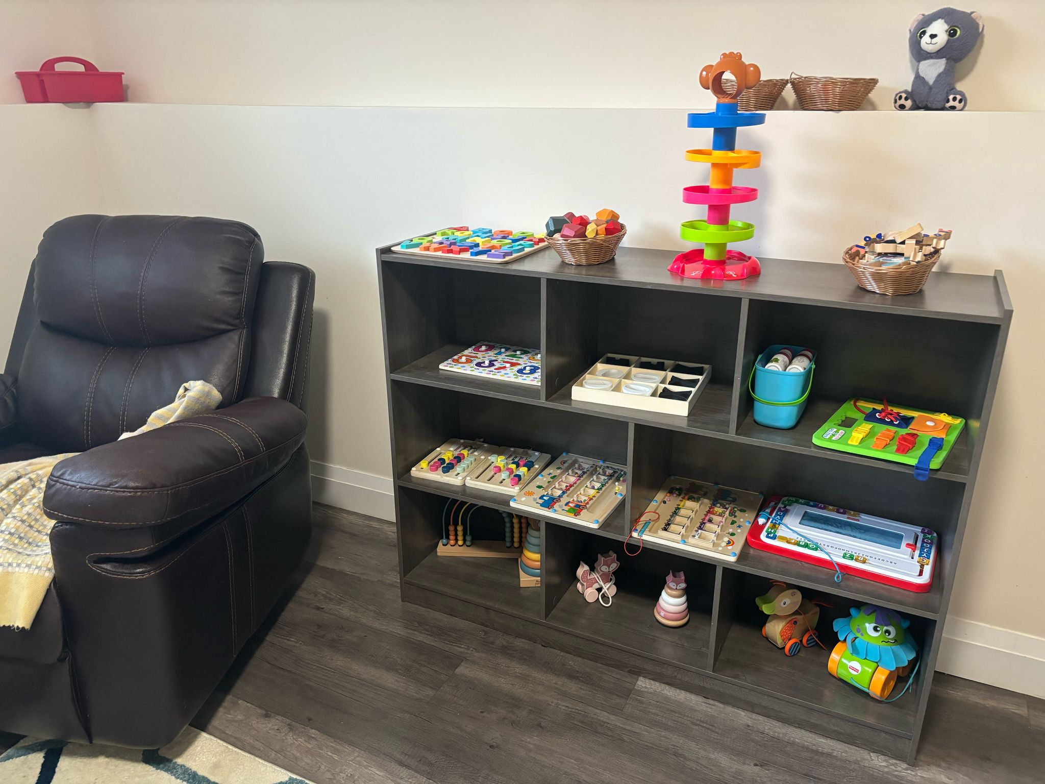 Cozy reading nook with educational toys, busy boards, and a comfortable chair